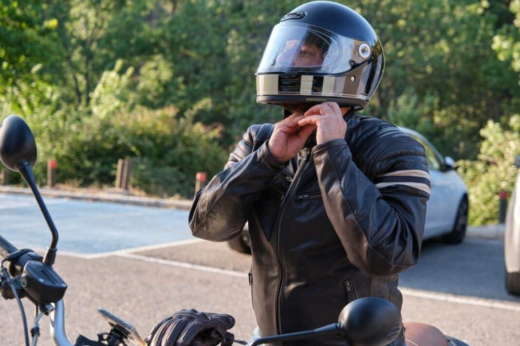 homme sur sa moto qui met son casque